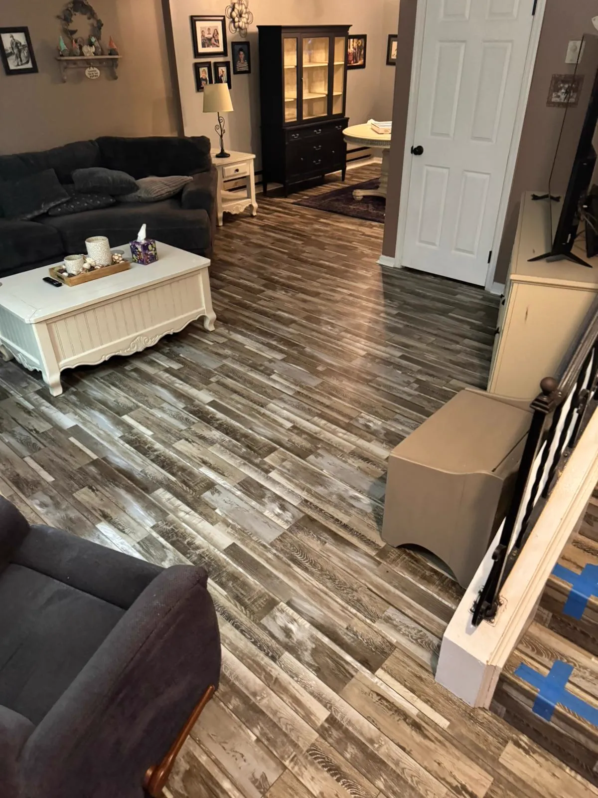 Distressed wide-plank flooring in a living room with mixed grey and brown tones